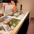 2名掛けベンチシートのカウンター席♪もちろんお一人も大歓迎です！海をモチーフにしたガラス張りのテーブルにはお客様から頂いたメッセージがずらり♪