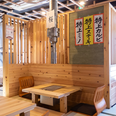 和の落ち着きとモダンな機能性が融合した空間が魅力。温かみのある木材をふんだんに使った内装は、居心地の良さからまるで自宅にいるようなリラックス感。壁にはレトロなポスターやハンガーラックが飾られ、懐かしさと遊び心を感じます。伝統的な和の雰囲気と現代的な焼肉スタイルが調和した、温かくも洗練された空間です。