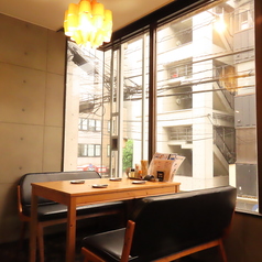シンプルで温かみのある木製テーブルと快適な椅子が揃い、友人や家族との楽しい会話を引き立てます。大きな窓からは外の景色が見え、開放感も感じられます。カジュアルな雰囲気の中で、ゆったりとした時間をお過ごしいただける席です。