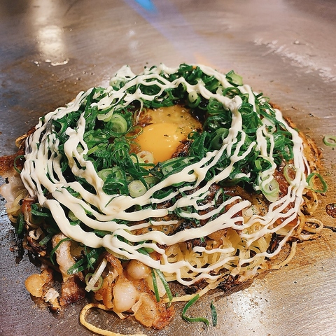 たっぷりのネギと卵黄、炙りマヨが食欲をそそる！熱々の鉄板で味わう絶品お好み焼き