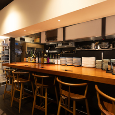 おひとり様でも気軽に立ち寄れる、アットホームな雰囲気のカウンター席。スタッフとの会話を楽しんだり、料理が出来上がる様子を眺めたりと、ひとりでも退屈せずに過ごせる特等席です。お仕事帰りの一杯や、ちょっとした気分転換にもぴったり。温かみのある空間で、ほっと一息つきませんか？