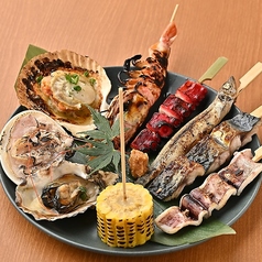 炉端の宝盛り！焼き牡蠣・殻付きホタテ・大海老・ヤリイカの豪華盛り合わせの写真