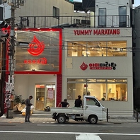 大きな交差点の角の二階建ての白い建物です！