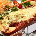 ［伊勢海老チーズ焼き］ 伊勢海老の半身にチーズをのせてオーブンで焼き上げた逸品。