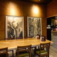 店内中央には、木の温もりを感じる立派な一枚板風の大きなテーブル席をご用意しております♪壁に飾られた大迫力のアート作品が目を引く、洗練されたお洒落な空間です◎ゆったりとお座りいただける広々としたお席なので、グループでのご利用にもおすすめ!奥にはお一人様でも気軽に過ごせるカウンター席もございます♪
