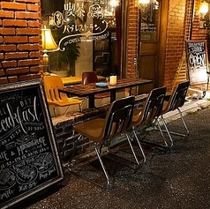 【テラス席】お店の顔である赤いレンガ壁を背景に、気軽に過ごせるテラス席をご用意しています。朝の光や夜のムードある照明の下で、開放的なひとときをお楽しみいただけます。モーニングやランチのカフェ利用はもちろん、ディナータイムには通りを眺めながら食事やカクテルを楽しむ、リラックスした時間をお過ごしください