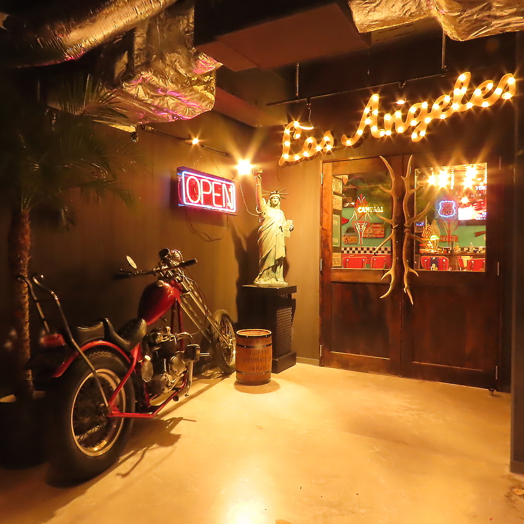 お店の前ではネオンサインとワイルドなバイクがお出迎え。一歩店内に入ると、ロサンゼルスがそこに？