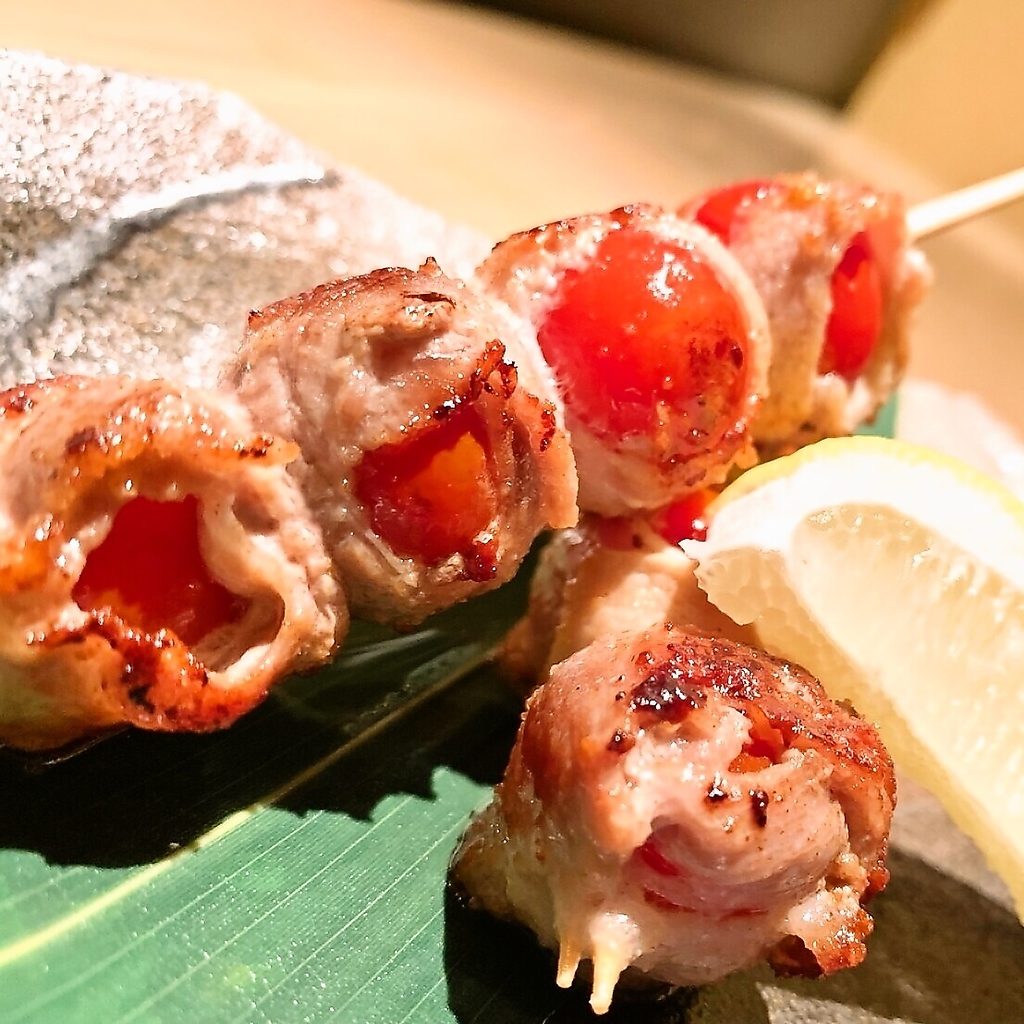 当店オススメメニューの一つ「トマトの肉巻き串」！肉の旨みとトマトの酸味が絡み合い絶妙な美味しさ