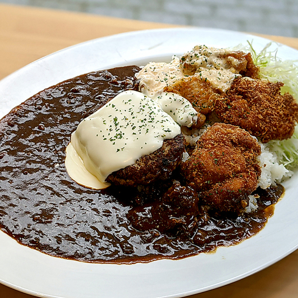 特盛カレーは、チキン南蛮、チキンカツ、ハンバーグが盛り合わさった、ボリューム満点の贅沢な一皿 