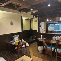 木製テーブルを囲むように、赤紫、深緑、芥子色の鮮やかな座布団を配置。日本の伝統色を取り入れた、華やかで活気のある団欒スペースです。