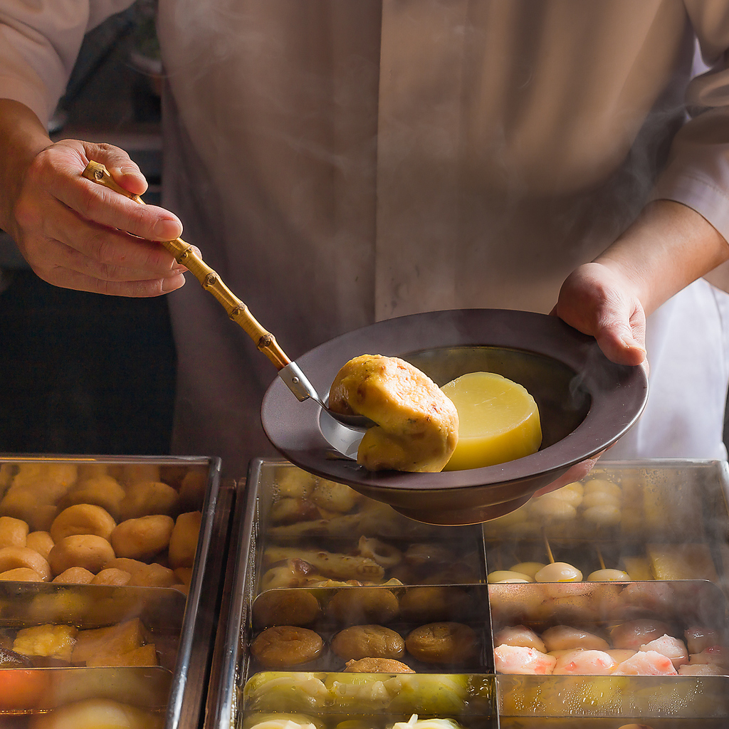鰹・地鶏・味噌の三種出汁が染み渡る自慢のおでん。名物の蛸巾着や地鶏つくねを、日本酒と共に堪能。