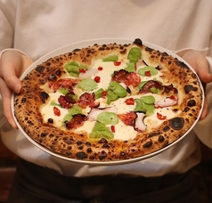 カラブリア産唐辛子とタコ、そら豆、リコッタチーズのピザの写真