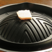 【美味しいジンギスカンの食べ方[1]】鍋が熱くなってきたら、脂を鍋全体に塗りなじませてください。塗り終わった脂は鍋のてっぺんに置きます。