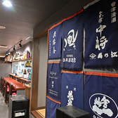 こだわりの地酒を象徴する藍色の前掛けが壁一面に飾られた店内は、落ち着いた和の情緒が漂います。木の温もりを感じるカウンター席は、お一人様やデートでゆっくり語らうのに最適です。厳選された日本酒と心尽くしの一皿を嗜みながら、都会の喧騒を忘れる至福のひと時をお過ごしください。