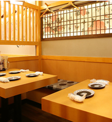 木目調のテーブル席を13席用意しており、1卓4名～で案内しています。仕事帰りの食事や友人同士の飲み会など、少人数で料理と会話を楽しみたい場面に適した配置です。複数卓の利用でグループ利用にも対応しており、田町での日常的な食事や集まりなど幅広い用途で利用されています。料理提供の動線も確保されています。