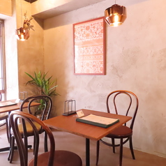落ち着いた照明とアンティーク調の椅子が心を和ませるテーブル席。コンクリート壁の風合いと観葉植物の彩りが絶妙に調和し、ゆったりとした時間が流れます。デートやご友人との集まりにもピッタリです◎