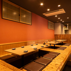 【掘りごたつ席:8名様×1卓、4名様×2卓】会社のお集まりやご友人とのお食事など、少人数から大人数まで様々なシーンにおすすめな掘りごたつ席。一列に並ぶ席は最大で24名様までのご利用に対応可能です。テーブルや床は木製にすることで、木の温もりを感じる温かい雰囲気のお席となっています。