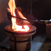 店内で、迫力ある炎で焼き上げる「黒焼きファイヤー」高温の炭火で一気に炙り、外はパリッと、中はジューシーに仕上げています。この豪快な調理法が、香ばしい薫りと独特の食感を生み出します◎