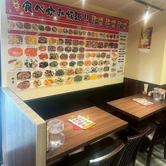 木目調の落ち着いたテーブル席は、4名様でゆったりとお食事を楽しめる空間です。壁には豊富な中華料理の写真が並び、メニュー選びもワクワク！会社帰りの飲み会やご家族・ご友人との食事にぴったり♪
