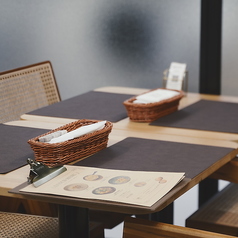 【木の温もりとワインの香りが似合うテーブル席】シンプルでモダン、木のぬくもりが感じられる空間は、女子会やランチ会、軽く1杯の集まりにもぴったり。美味しい料理を囲んで、自然と会話も弾む時間をお楽しみください。