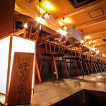 鮮魚の並ぶ活気あるカウンターには大漁旗や焼酎がズラリ！