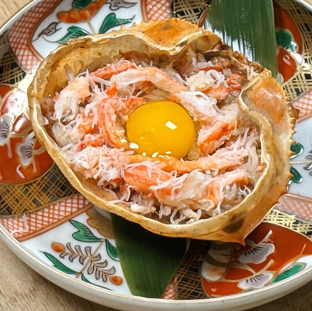見た目のインパクトも◎！「かに味噌甲羅焼き」はカニの身と玉子の黄身を絡めて召し上がって下さい。