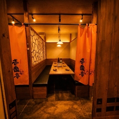木目調の壁と暖簾が落ち着いた雰囲気を醸す和風個室。温かみのある照明の下、ゆったりとした空間で本格料理と地酒を楽しめます。