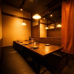 木の温もりと柔らかな照明が心地よい半個室。すりガラスの仕切りと暖簾で程よいプライベート感があり、落ち着いた雰囲気で会話と食事を楽しめます。
