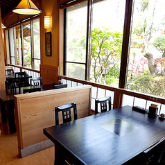 すべての席から日本庭園が見えるテーブルでお食事をお楽しみいただけます。半個室感覚の仕切り（ついたて）もご用意できます。