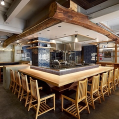 【1階：カウンター12席】木の温もりを感じるカウンター席では、藁焼きの様子を眺めながら、目の前で料理が仕上がるライブ感を楽しむことができます。ぜひお気軽にお立ち寄りください。