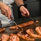 【鉄板焼き】目の前の鉄板で豪快に焼き上げるライブキッチン。ジュワッと響く音や立ち上る香りなど、出来上がる瞬間まで楽しめます。熱々の美味しさを出来立てでご堪能ください。
