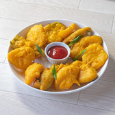 野菜（タマネギ、ジャガイモ、なす、カリフラワーなど）をスライスしたものにチャナ豆をひいた粉を付けて揚げた日本の天ぷらのようなものです。生姜やガラムマサラ・アジョワンシード・カイエンヌペッパーなどでよく下味をつけます。