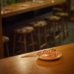 一歩足を踏み入れた瞬間、静けさと香ばしい香りに包まれる。全席カウンターの店内では、料理人が目の前で藁焼きの調理を披露。立ちのぼる煙、火の音、香ばしい香り──五感を通して料理と向き合える“体験の場”です。