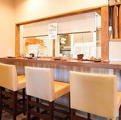 木目調の明るいカウンター席で、ゆとりある空間と清潔感を楽しめます。ベージュの椅子が並び、温かみのある照明が心地よく、料理と会話が自然に弾む雰囲気です。カウンター越しに料理人の手際を眺めながら、落ち着いた時間を過ごせるのも魅力。