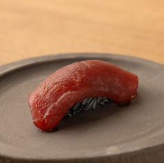 黒シャリという名のインパクト。それは、見た瞬間に記憶に残る美しさ。色鮮やかなネタと黒シャリの寿司。の写真
