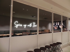シンプルでモダンな内装が特徴です。「Spice up with Thai」のネオンが印象的で、落ち着いた雰囲気の中でタイ料理を楽しめます。