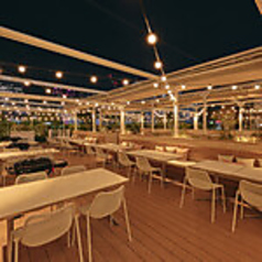 【BBQエリア】ライトアップが素敵空間を作り出す、エネルギッシュな夜のBBQ席。お酒が進む雰囲気の中、仕事帰りの宴会やパーティーに最適です。冷えたビールを片手に、夜風を感じながらグリル料理を楽しむ贅沢な夜。賑やかながらも都会的な、洗練されたBBQスタイルを提案します。