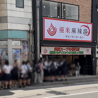 大きな交差点の角の二階建ての白い建物です！