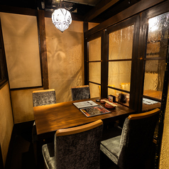 温かみのある間接照明が照らす、落ち着いた和モダンの個室空間。木の質感と優しい色合いの壁、そして柔らかく光を通すガラス格子が、上質で静かな時間を演出します。プライベート感のある個室で、炉ばた料理とともに心ほどけるひとときをお過ごしください。