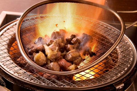 鶏の炭火焼を七輪でお客様が専用ざるを使って本場の薫り高い鶏の燻しを体験！