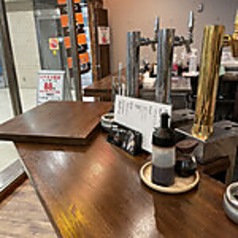 厨房をぐるりと囲む巨大な「コ」の字カウンターが圧巻です。壁一面に貼られた手書きの短冊メニューが酒場好きの心をくすぐり、隣のお客さんとも自然と距離が縮まる、活気あふれる空間です。