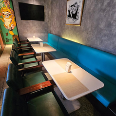 ターコイズブルーのソファが映えるおしゃれなテーブル席。落ち着いた雰囲気で、女子会やカフェタイムにぴったりの空間です。