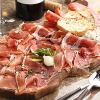 木製プレートに乗っかる大量の生ハムを皆様まで♪