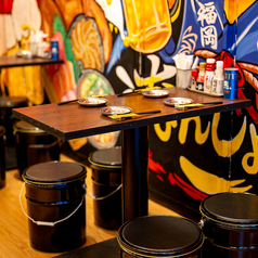 【博多中洲屋台を再現】博多中洲屋台村 なんしょっと？を象徴する『巨大壁絵』を眺めながら臨場感ある宴会や飲み会などに抜群のテーブル席となっております。店内にはTVモニターも完備しておりスポーツ観戦にも最適な空間となっております！