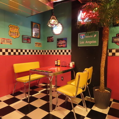 80年代のアメリカンダイナーを思わせるオシャレなテーブル席♪ビビッドカラーの鮮やかなテーブルとイスで気分もアガる！ヤシの木やネオンの光でさらに雰囲気アップ♪