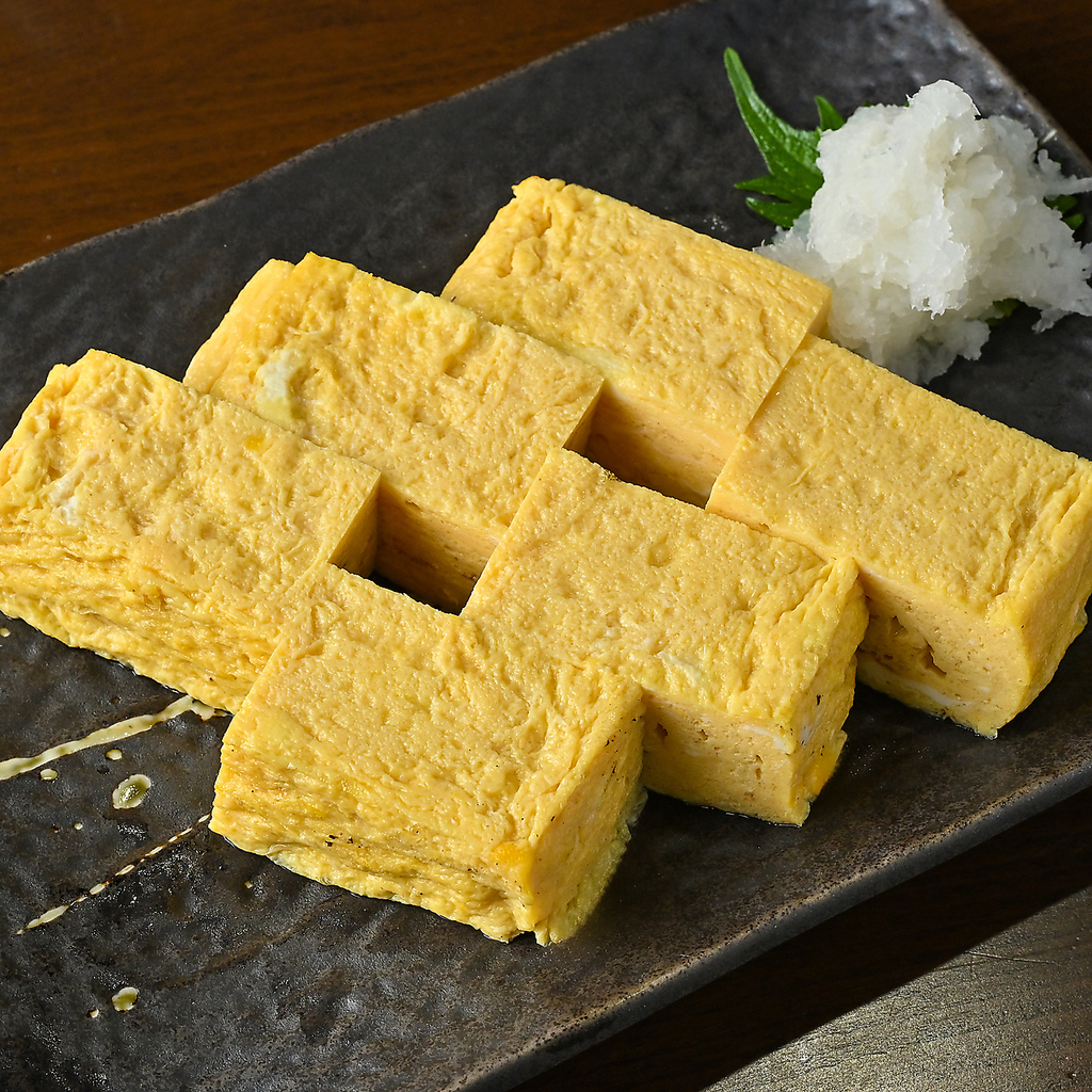 ふわふわ食感と出汁の旨みが溢れ出す。職人技が光る、熱々の厚焼き玉子を大根おろしと共に味わって。