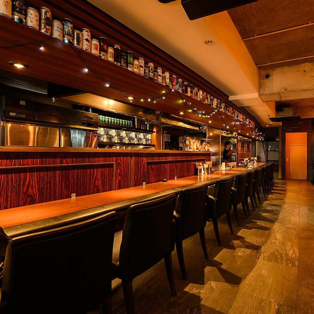 お一人様も大歓迎なカウンター。ずらりと並ぶビール缶のディスプレイに、気分も高まります。