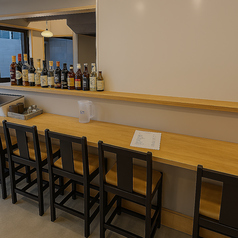 木の温もりを感じる落ち着いたカウンター席が並ぶ、居心地の良い店内空間。お一人様でも気軽に立ち寄れる雰囲気で、調理の臨場感を楽しみながら食事ができます。仕事帰りの一杯やゆっくりと味わうディナーにも最適な、大人が寛げる空間です。