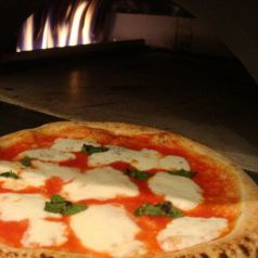 石窯で焼き上げるピッツァの写真