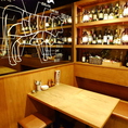 【１階テーブル席】ワインやシャンパンのボトルがオシャレ。男女問わず、気取らずラフに肉とお酒を満喫できる空間が嬉しい。